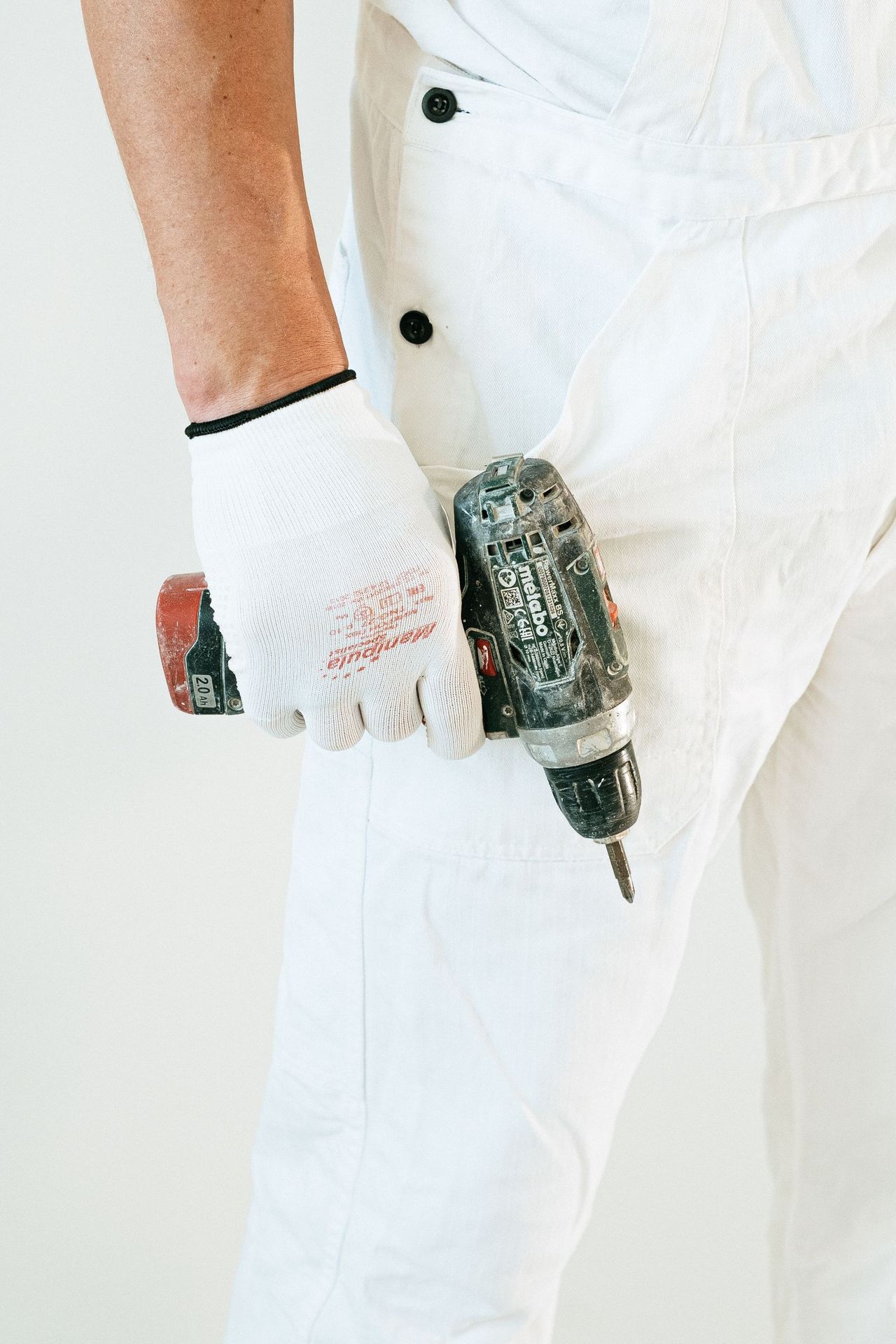 Técnico con guantes y taladro listo para trabajar